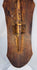 Historic cracks, surface wear, and old stabilization visible on the carved wooden shield