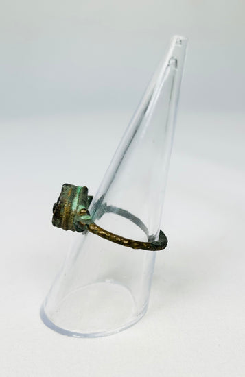Ancient bronze artifact ring tilted on a transparent display stand