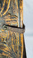 Oxidized iron strap latch mounted on a traditional carved wooden cabinet