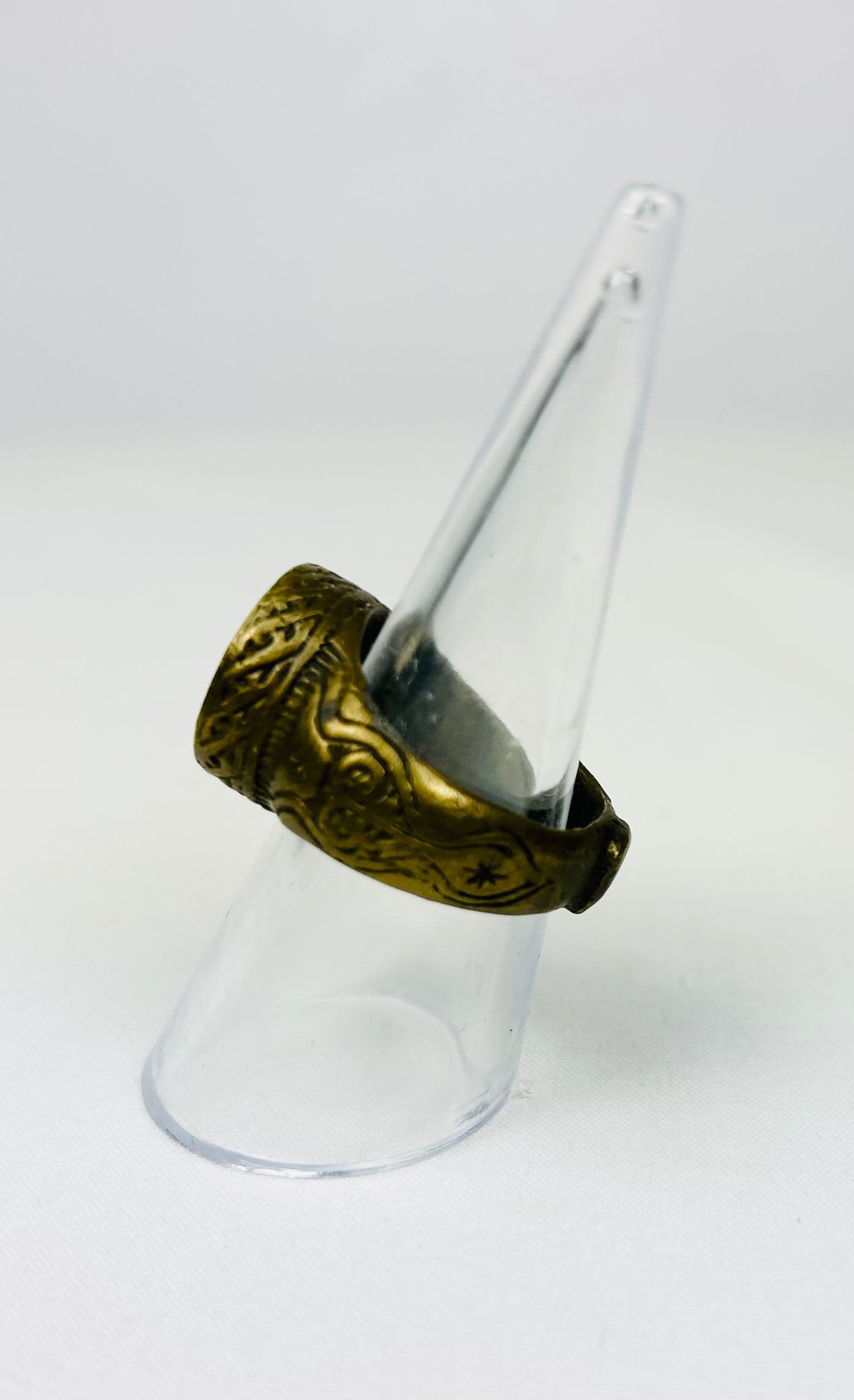Bronze Roman-era ring displayed on a white surface with detailed carvings
