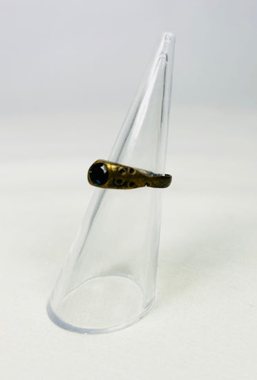 Antique brass ring with circle-dot engraving on a white background