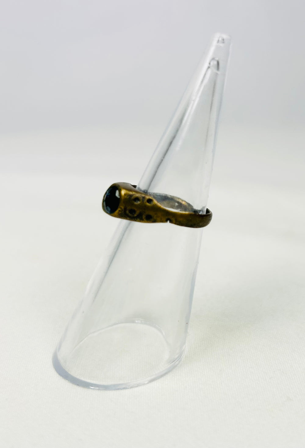 Late Roman brass ring displayed on a clear cone stand