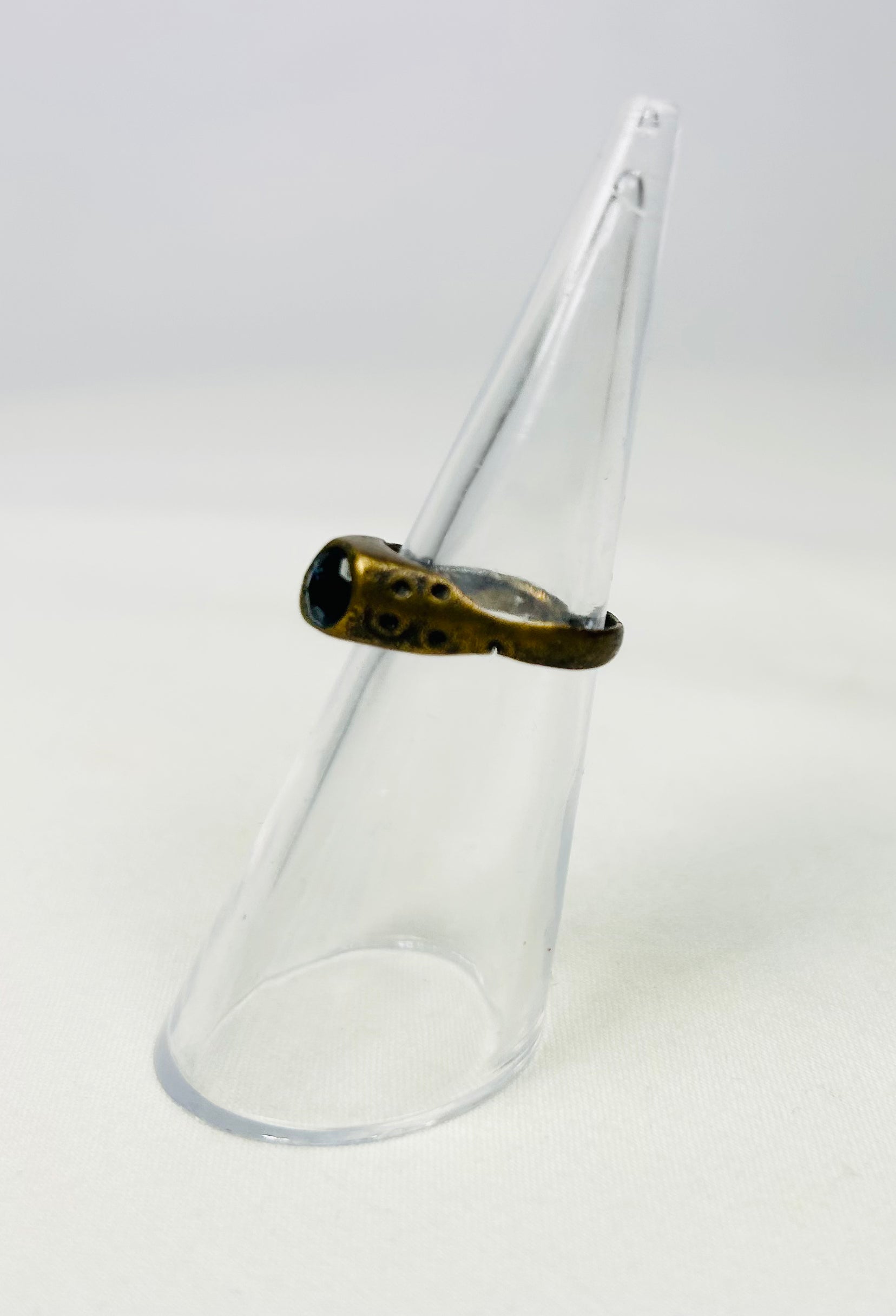 Late Roman brass ring displayed on a clear cone stand