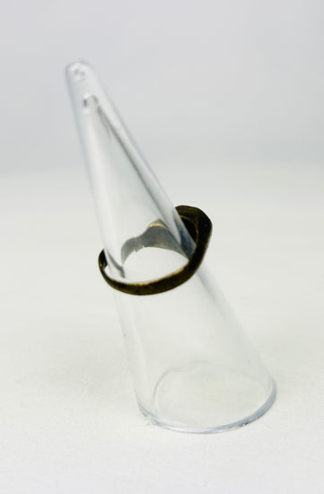 Ancient metal ring with incised geometric design on stand