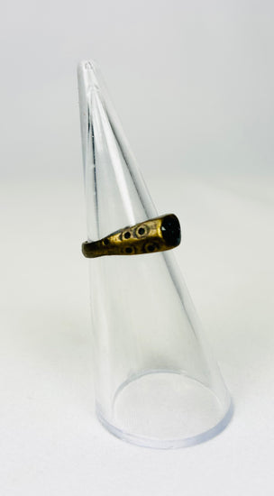 Brass ancient ring with worn engraving on display