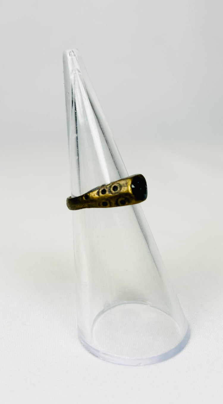 Brass ancient ring with worn engraving on display