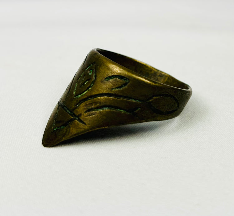 Antique engraved thumb ring shown on black stand