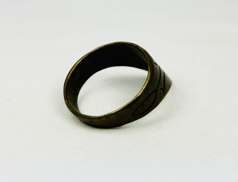 Angled view of antique thumb ring on white background