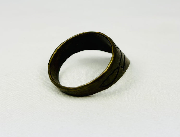 Angled view of antique thumb ring on white background