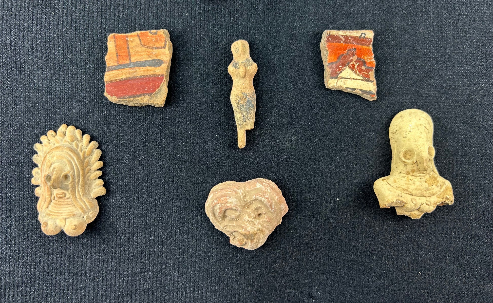 Assortment of Pre-Columbian figurines and ceramic relics mounted inside a display case