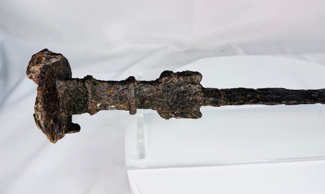 Close-up of the lion-head disc pommel on an Iron Age Luristan sword, highlighting its sculptural form and ancient surface patina.