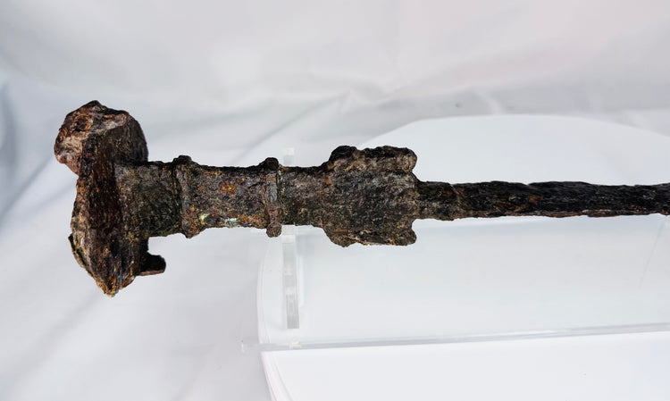 Close-up of the lion-head disc pommel on an Iron Age Luristan sword, highlighting its sculptural form and ancient surface patina.