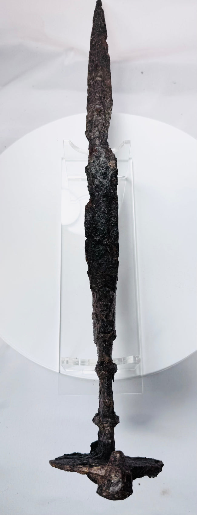Detailed photograph of an Iron Age Luristan sword showing its lion-head pommel, ribbed grip, double-edged blade, and centuries-old oxidation.