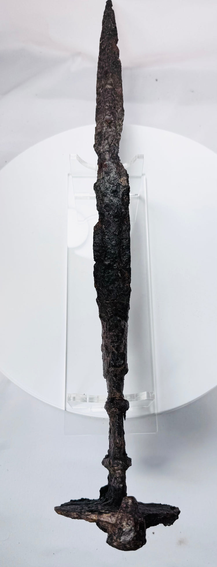 Detailed photograph of an Iron Age Luristan sword showing its lion-head pommel, ribbed grip, double-edged blade, and centuries-old oxidation.
