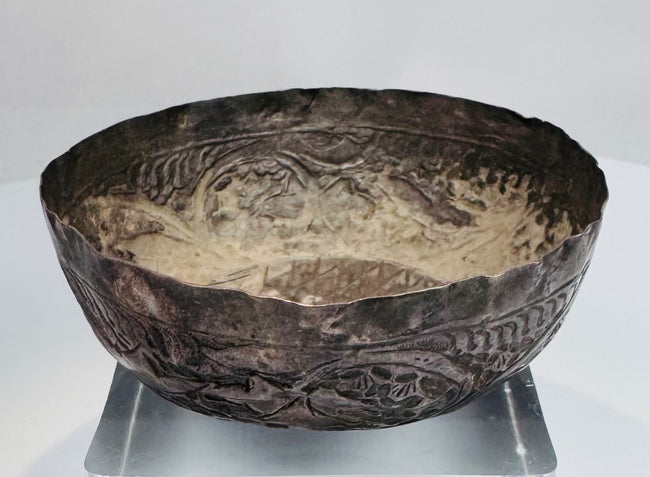 Medieval Persian silver unguent vessel with a shallow rounded form, uneven rim, and centuries-old natural patina.
