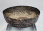 Medieval Persian silver unguent vessel with a shallow rounded form, uneven rim, and centuries-old natural patina.