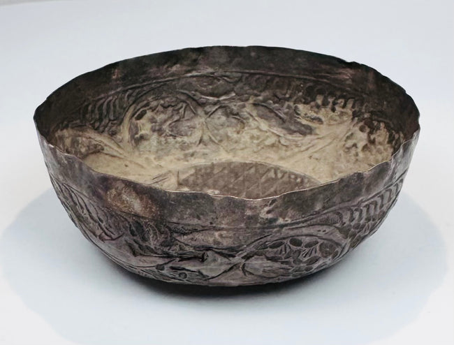 12th–13th century Persian silver bowl showing a compact circular form, aged interior surface, and slightly irregular hand-forged rim.