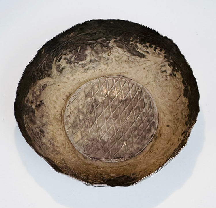 Interior of a Seljuk silver bowl showing natural oxidation, surface wear, and preserved hand-forged construction.