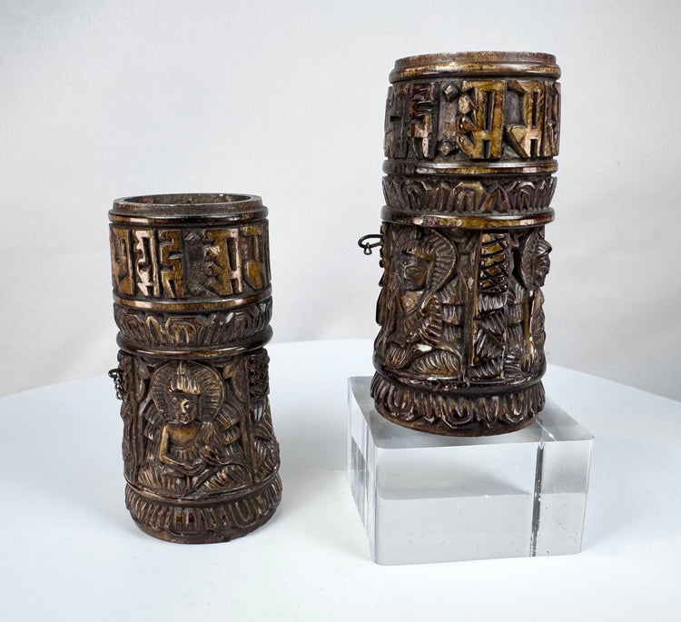 Pair of Tibetan Buddhist prayer wheels hand-carved from human femur bone, dating to the 18th–19th century and decorated with sacred relief imagery.