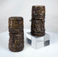 Tibetan ritual prayer wheels carved from human bone, featuring three relief-carved Buddha figures and bands of sacred inscriptions.
