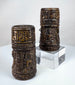 Close-up of hand-carved Buddha figures on Tibetan Buddhist human bone prayer wheels, each shown in a distinct mudra.