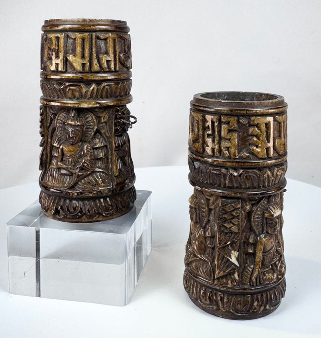 Pair of compact Tibetan prayer wheels measuring approximately 3.1 inches high and carved with Buddhist figures and inscriptions.