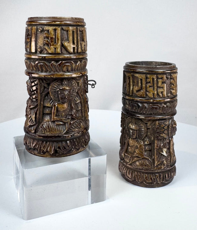 Human bone Tibetan prayer wheels with aged surfaces, carved Buddha imagery, and sacred script associated with Buddhist ritual practice.