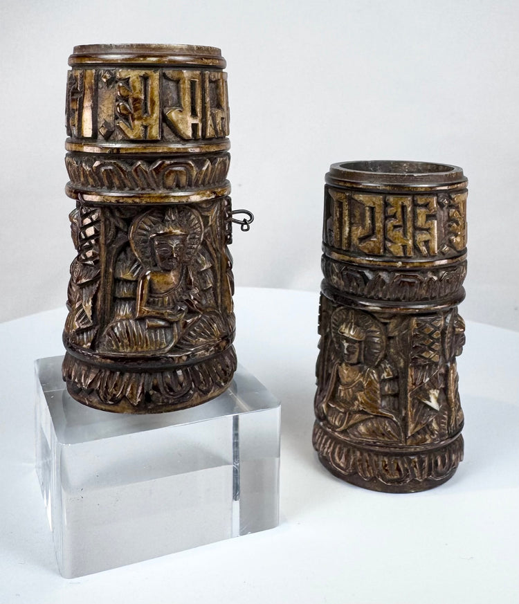 Human bone Tibetan prayer wheels with aged surfaces, carved Buddha imagery, and sacred script associated with Buddhist ritual practice.