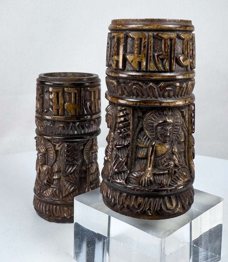 Antique Tibetan ritual prayer wheels fashioned from human femur bone and decorated with symbolic Buddhist devotional imagery.