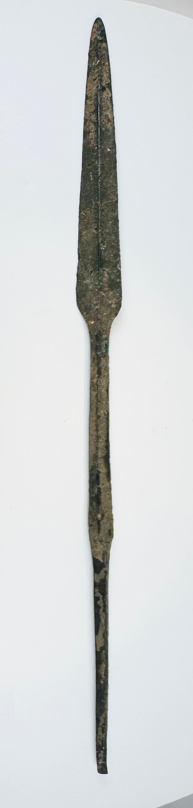 Early Bronze Age Cypriot bronze spearhead dating to circa 2500–1900 BCE, with a leaf-shaped blade, raised central ridge, straight tang, and ancient burial patina.