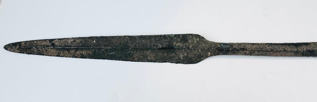 Ancient bronze spearhead from Cyprus featuring a tapered blade, reinforced four-sided midsection, preserved tang, and naturally oxidized surface from the Early Cypriot III period.