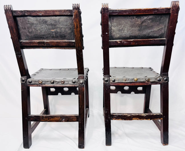 Antique leather-upholstered chairs with dark walnut frames and metal studs