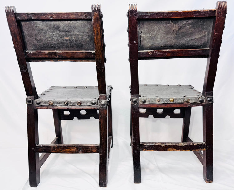 Antique leather-upholstered chairs with dark walnut frames and metal studs