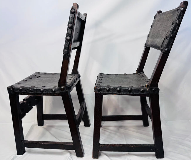 Side view of an antique Spanish walnut chair with leather seat and back