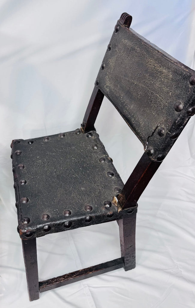 Rear view of Spanish Baroque chairs showing walnut frames and leather panels