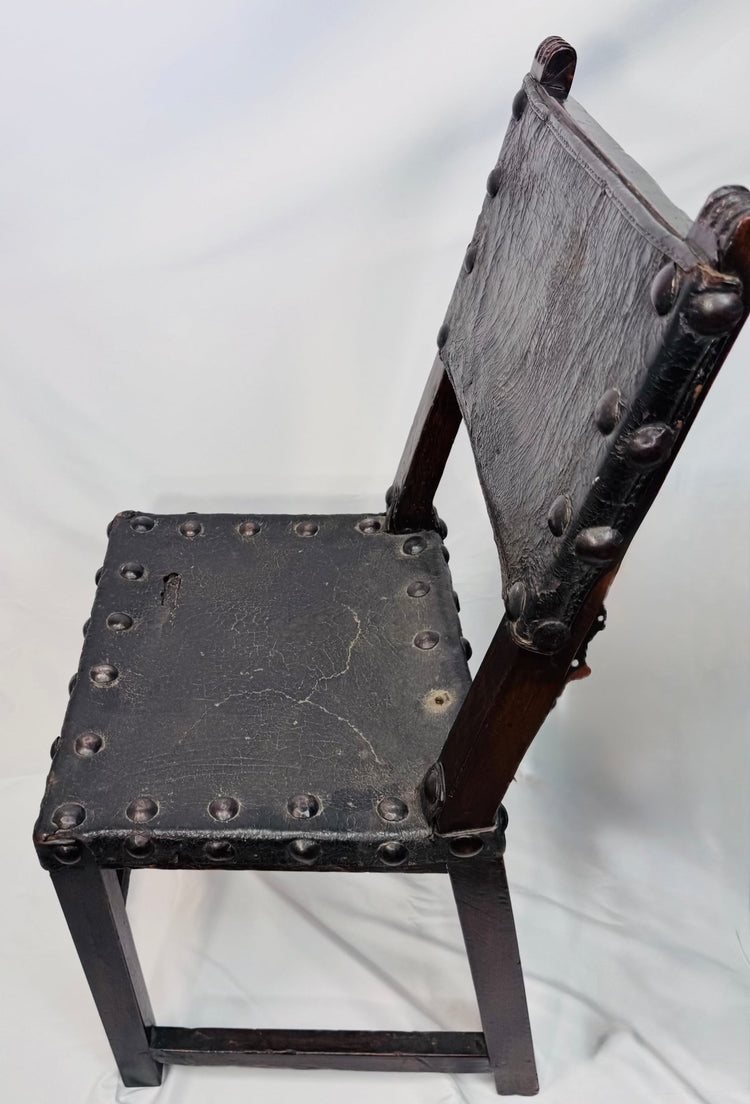 Close-up of carved crest-like terminals on a Spanish walnut chair