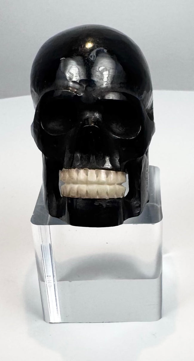 Side profile of an antique miniature horn skull sculpture