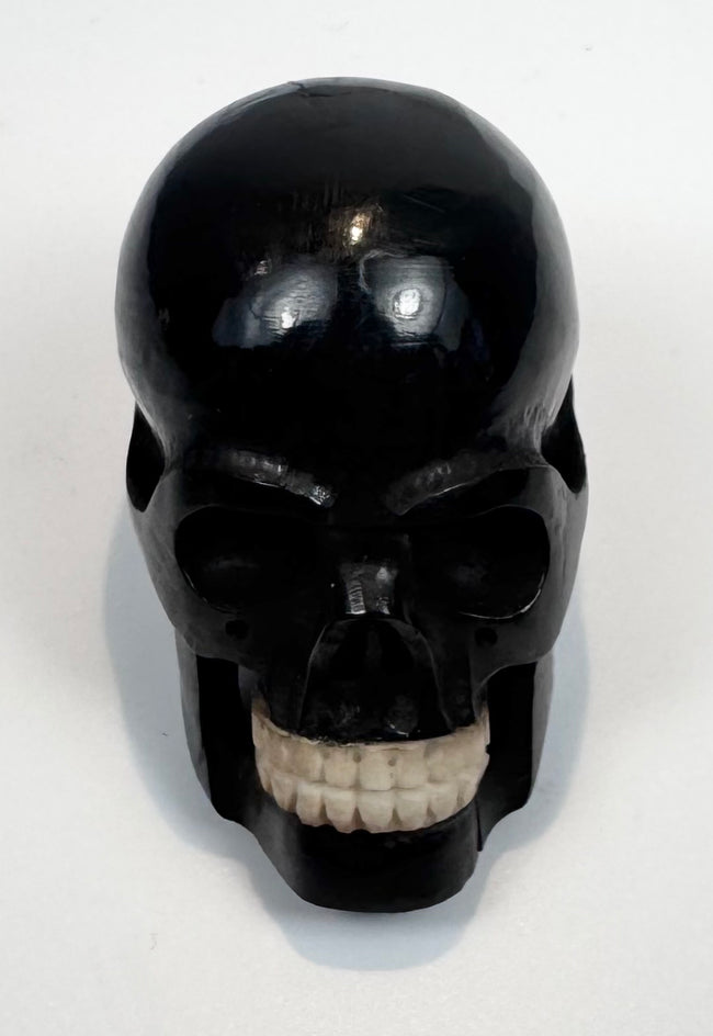 Detailed view of the contrasting tooth-like inserts in the carved skull