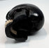 Small antique memento mori skull displayed on a clear acrylic block