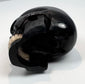 Small antique memento mori skull displayed on a clear acrylic block