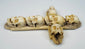 Close-up of carved skulls and articulated teeth on an antique bone cross