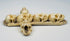 Side view of a six-skull memento mori cross carved from animal bone
