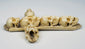 Side view of a six-skull memento mori cross carved from animal bone