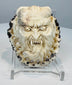 Japanese oni face carving with fangs, horns, and extended tongue