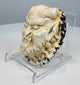 Side view of an antique antler demon plaque with undercut details