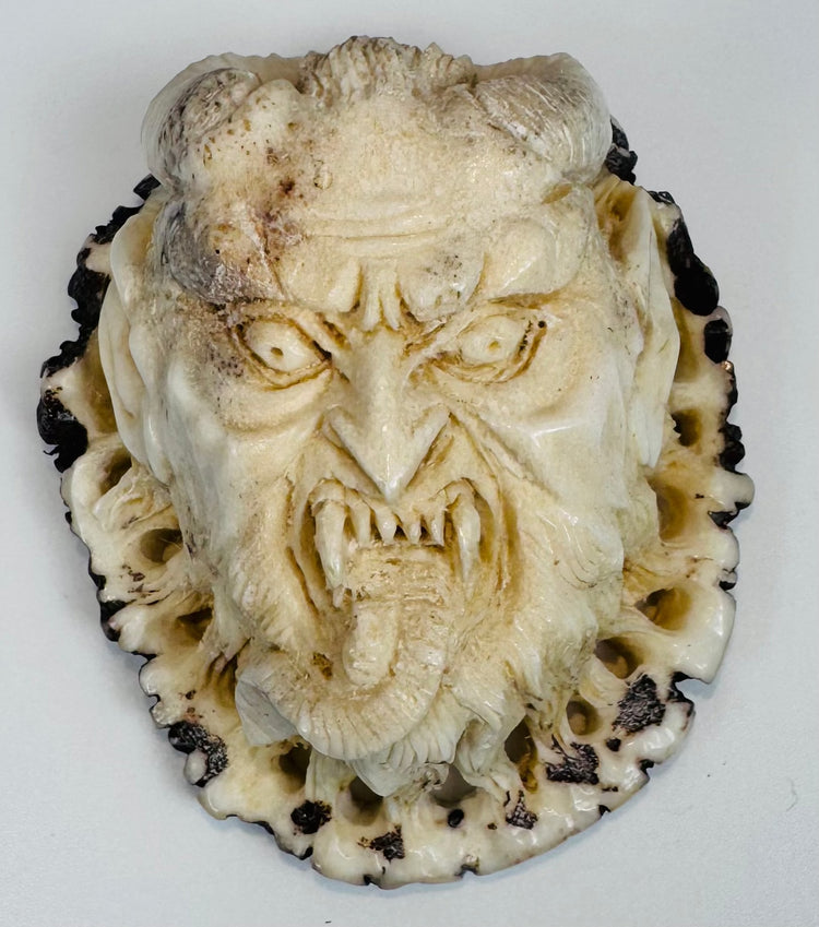 Hand-carved deer antler plaque depicting a fierce Japanese oni