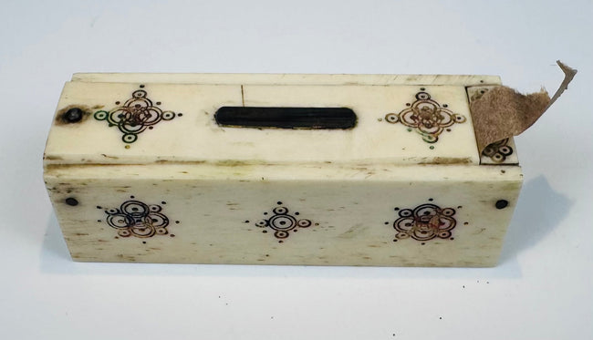 Side view of antique bone domino box with hand-worked decoration