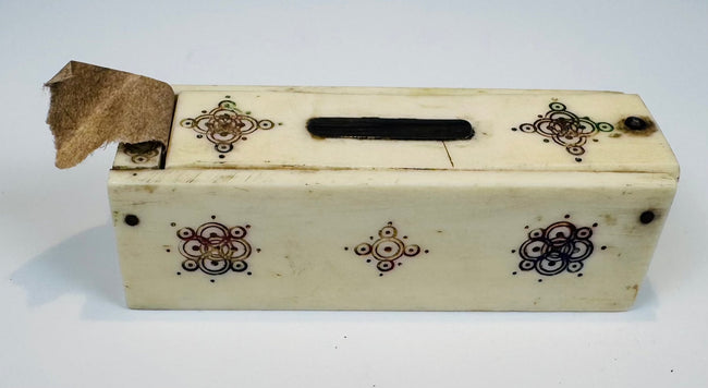 Decorative bone domino case showing black, brown, and green ornament