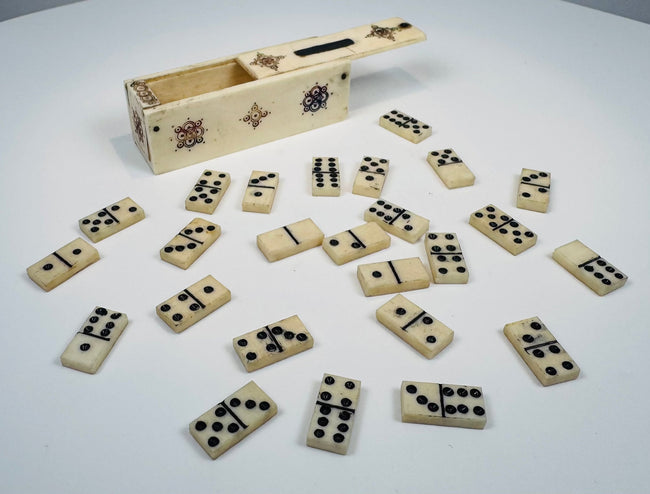 Close-up of antique bone domino tiles with dark inlaid pips