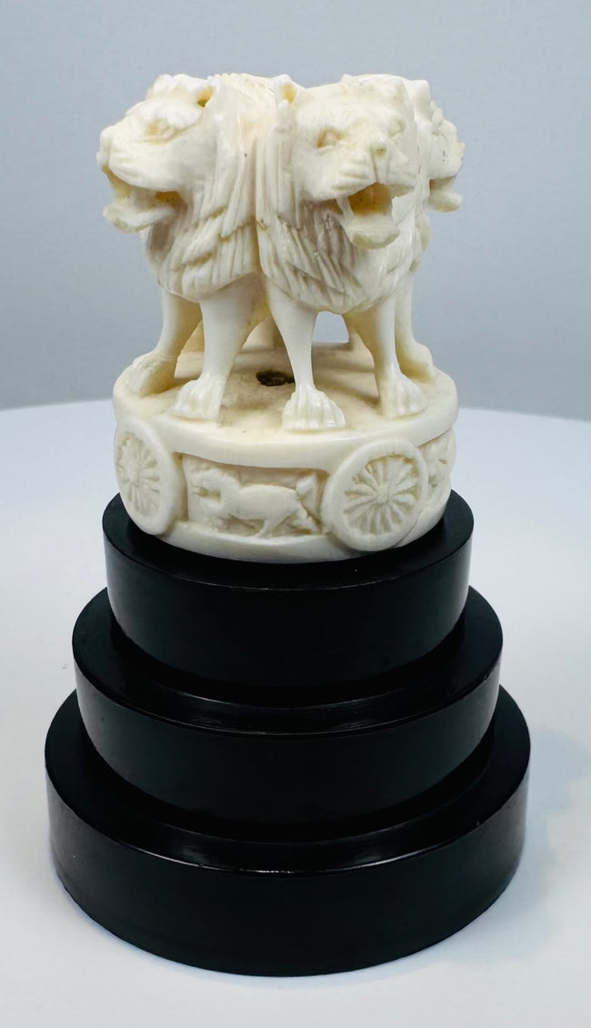 Pale bone-like Ashoka lion sculpture mounted on an ebonized pedestal